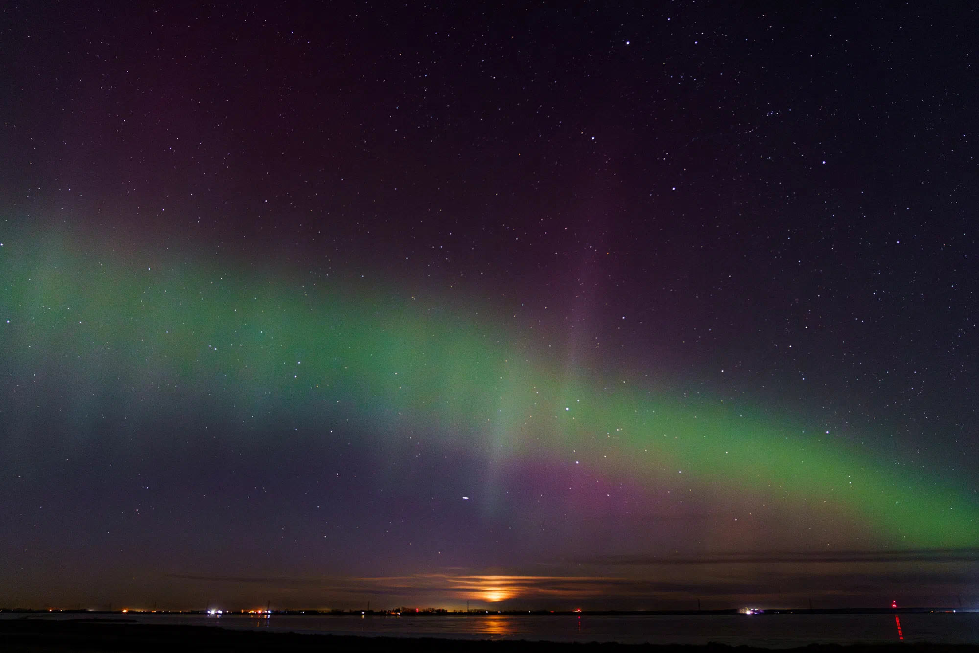 Moonrise behind the Northern Lights